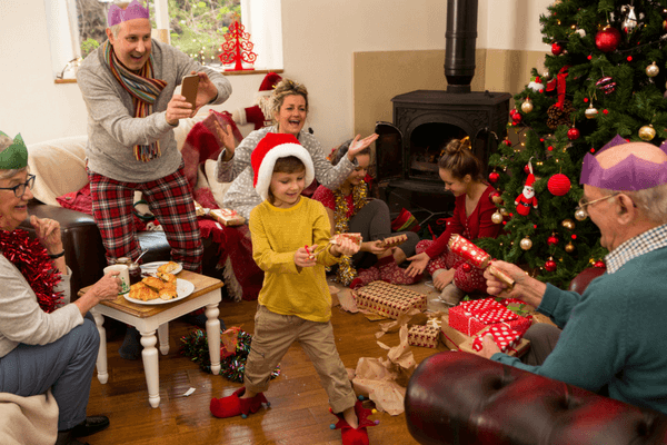 Kid playing a game in front of the Family during Christmas Gathering