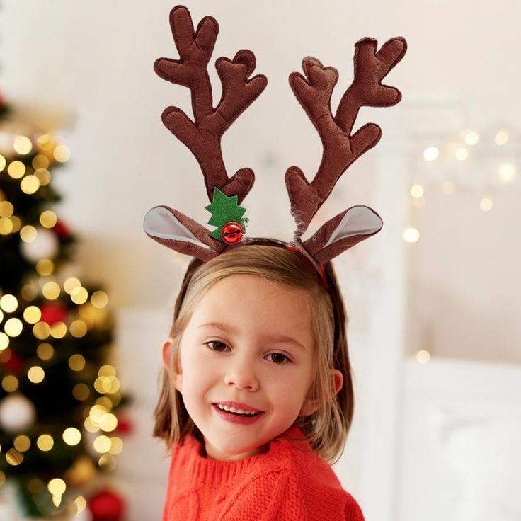 A little girl wearing Christmas Reindeer Antlers