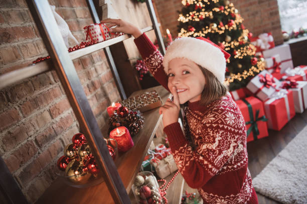 a sneaky kid hiding Christmas Gift.